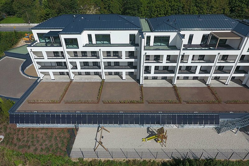 Luftaufnahme des nordwestlichen Abschnitts der Fassaden-Photovoltaikanlage des Panoramaparks in Cham-West