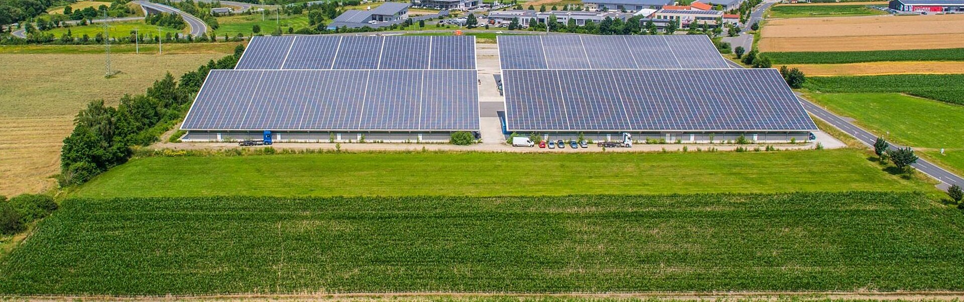 Luftaufnahme einer Photovoltaikanlage auf dem Pultdach einer Industriehalle