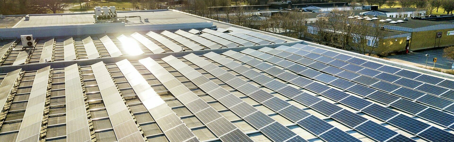 Photovoltaikmodule auf dem Dach eines Unternehmens, die einen Stromspeicher speisen